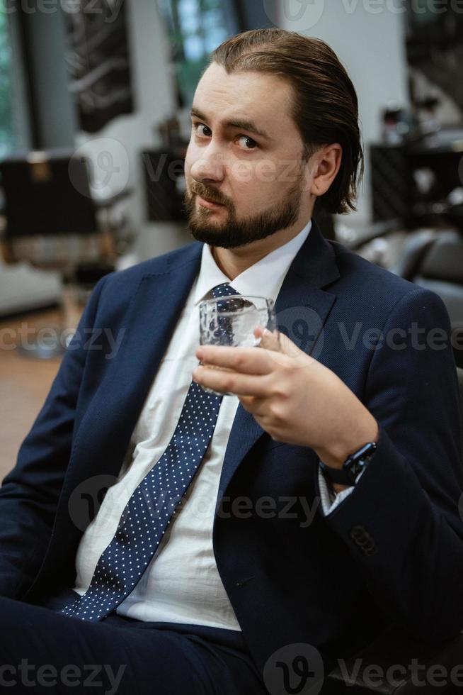 portrait of a male groom in a blue suit in the morning  barbershop photo
