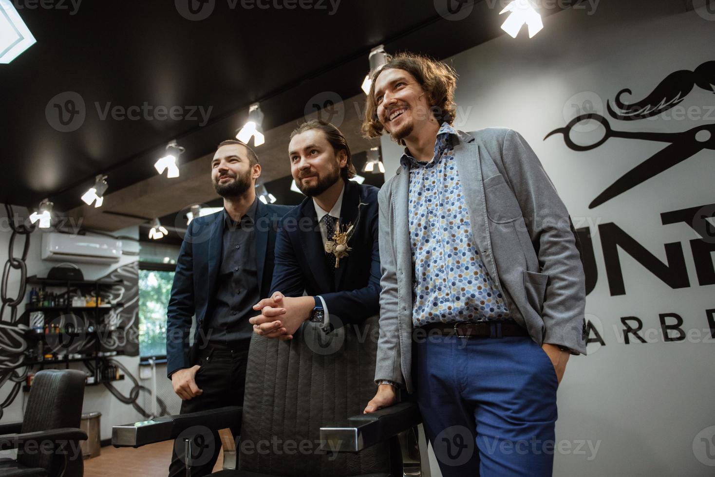 retrato de un novio masculino con traje azul en la barbería de la mañana foto