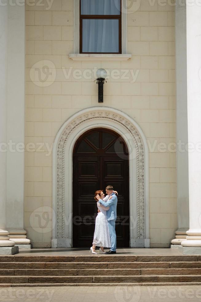 novia con un vestido de novia ligero al novio con un traje azul foto