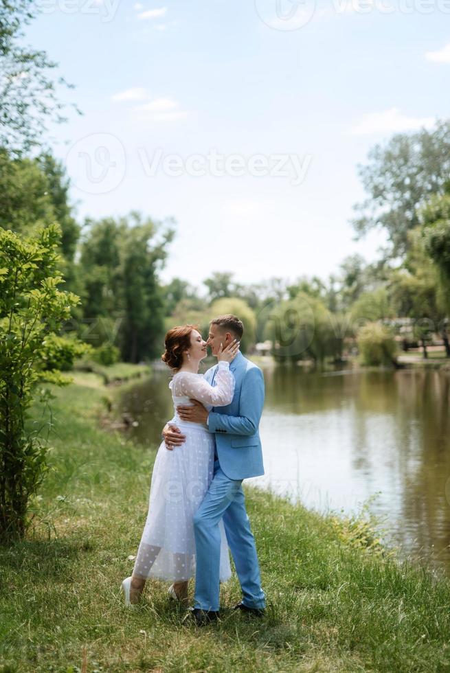 novia con un vestido de novia ligero al novio con un traje azul foto