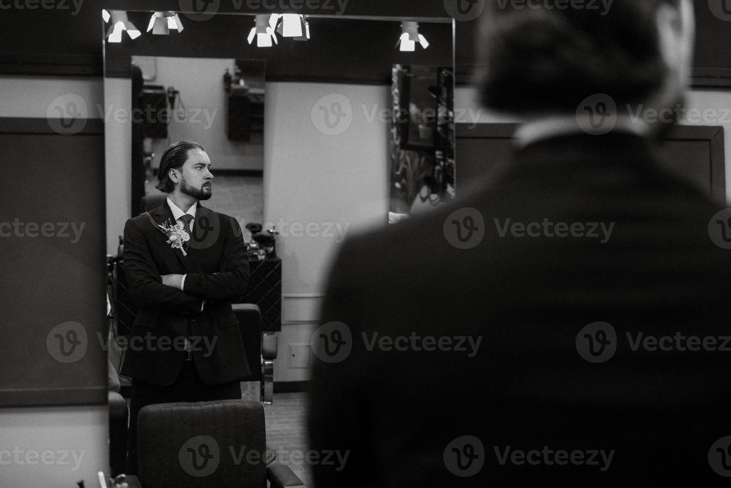 portrait of a male groom in a blue suit in the morning  barbershop photo