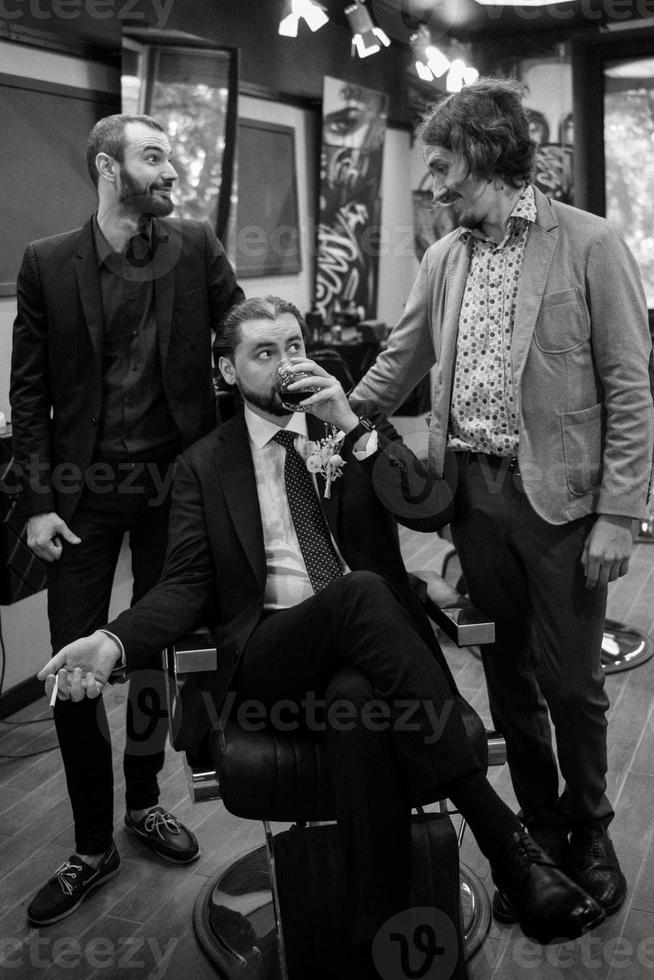 retrato de un novio masculino con traje azul en la barbería de la mañana foto