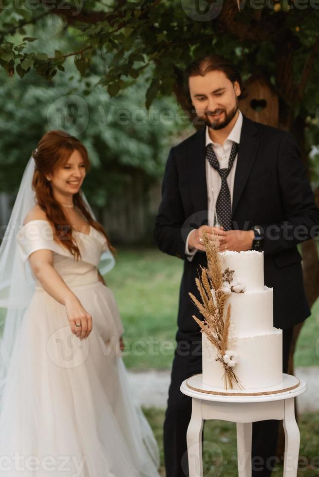 newlyweds happily cut and taste the wedding cake photo