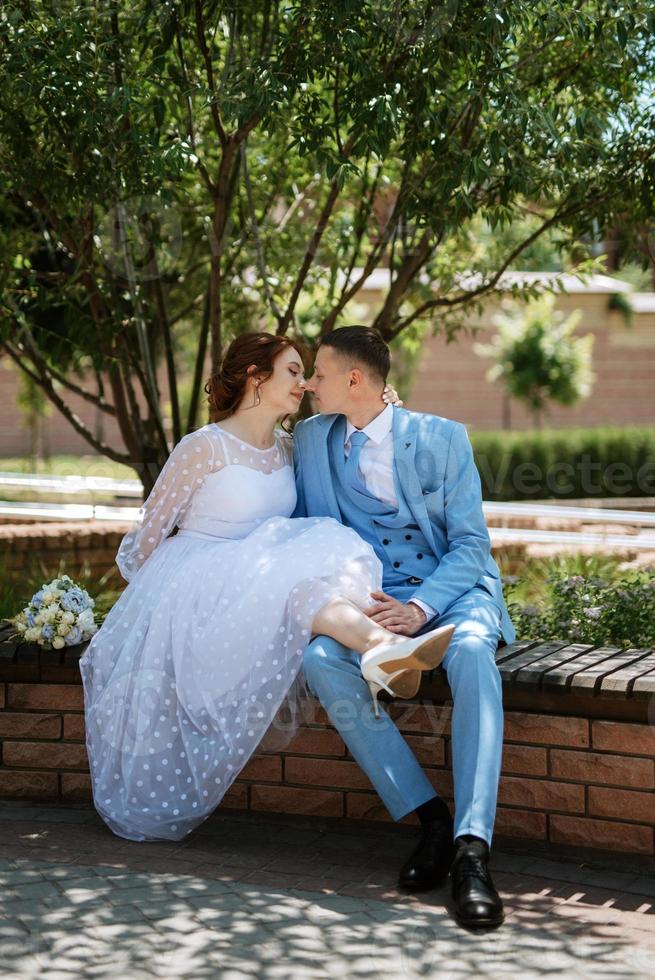 novia con un vestido de novia ligero al novio con un traje azul foto