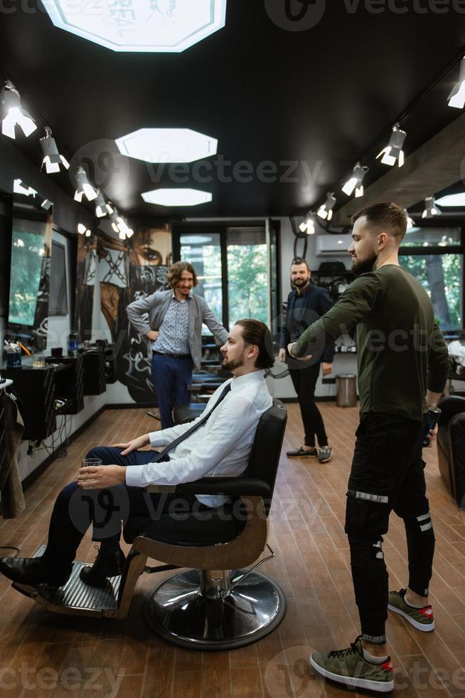 hombre barbudo cortándose la barba en la barbería foto