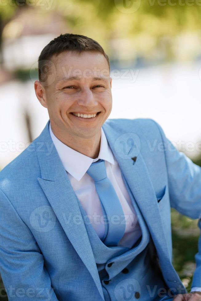 retrato del novio del novio con un traje azul sonriendo foto