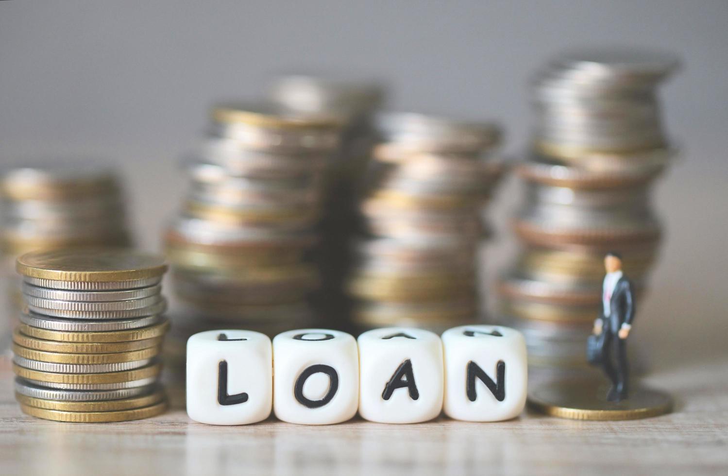 Loan business economy concept of money and finance on table, Loan business finance economy and business man standing on a coin on wooden table background photo