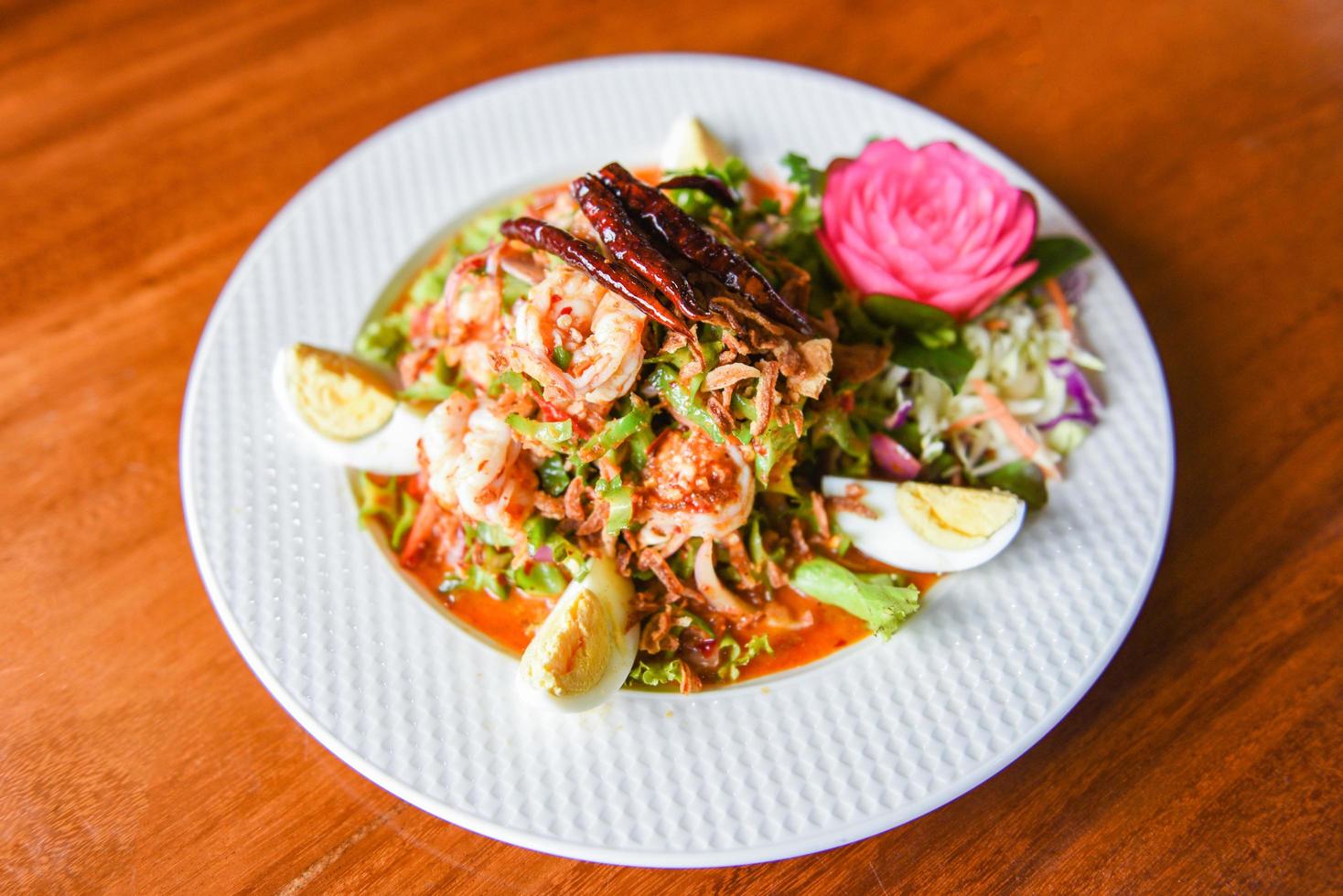 Wing bean shrimp salad spicy with boiled eggs on white plate - shrimp prawn seafood salad Thai food photo