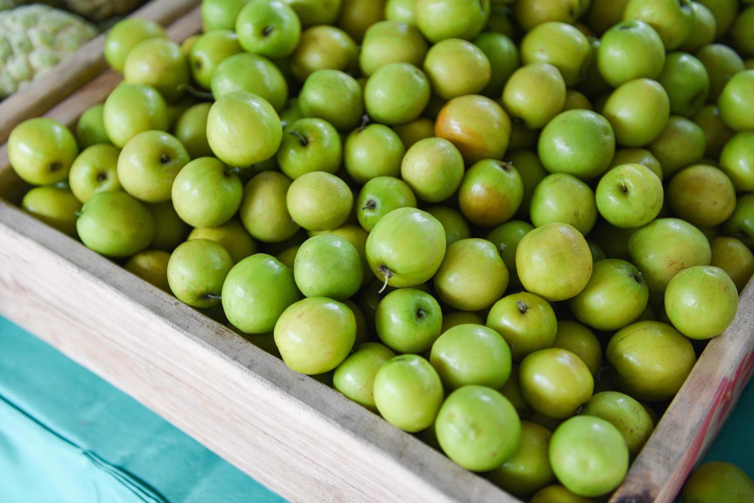 azufaifos verdes en caja de madera en el mercado de frutas asiático - fruta de manzana de mono foto