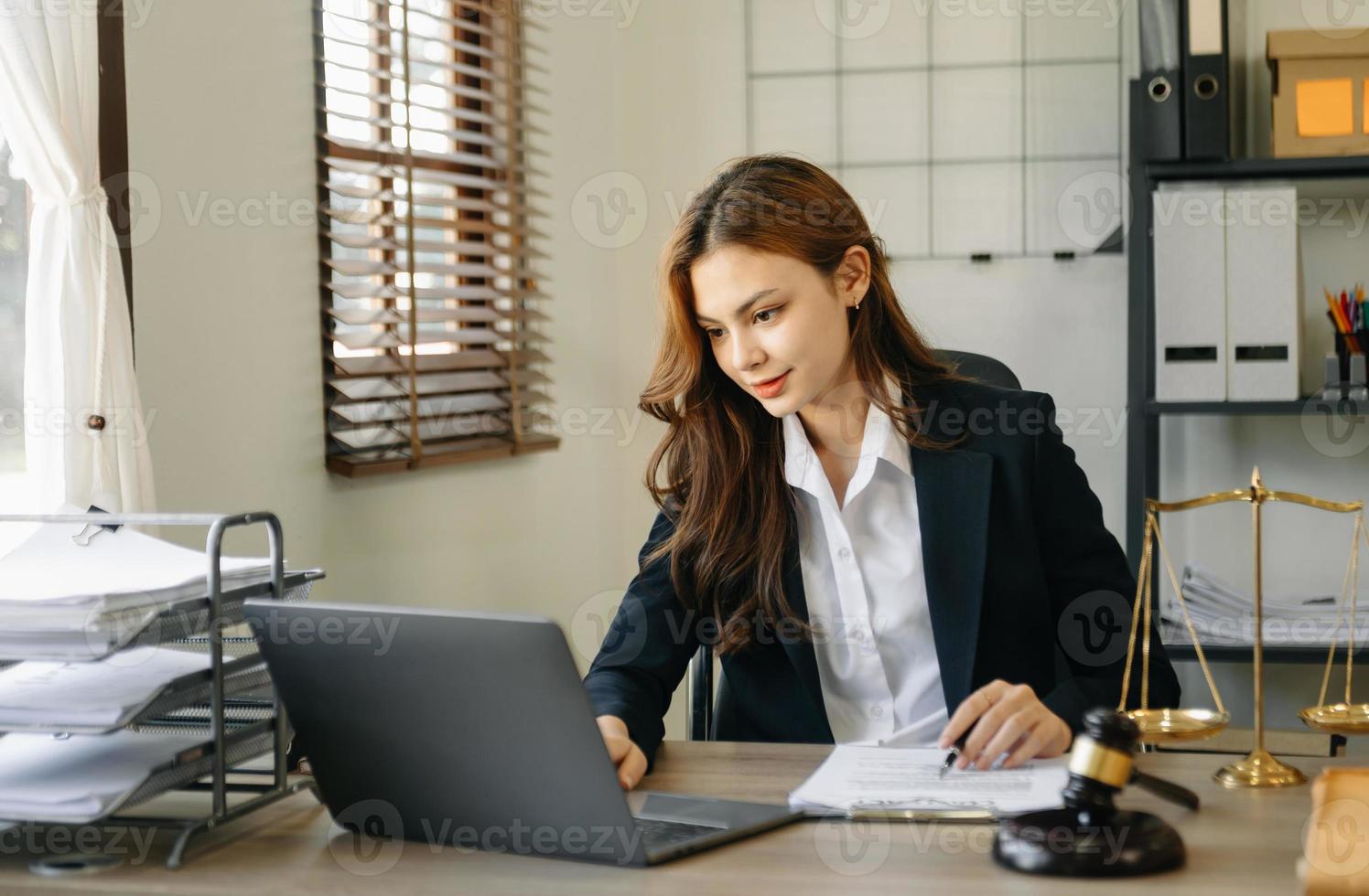 bella abogada asiática trabajando y martillo, tableta, computadora portátil al frente, consejo de justicia y concepto de ley. foto