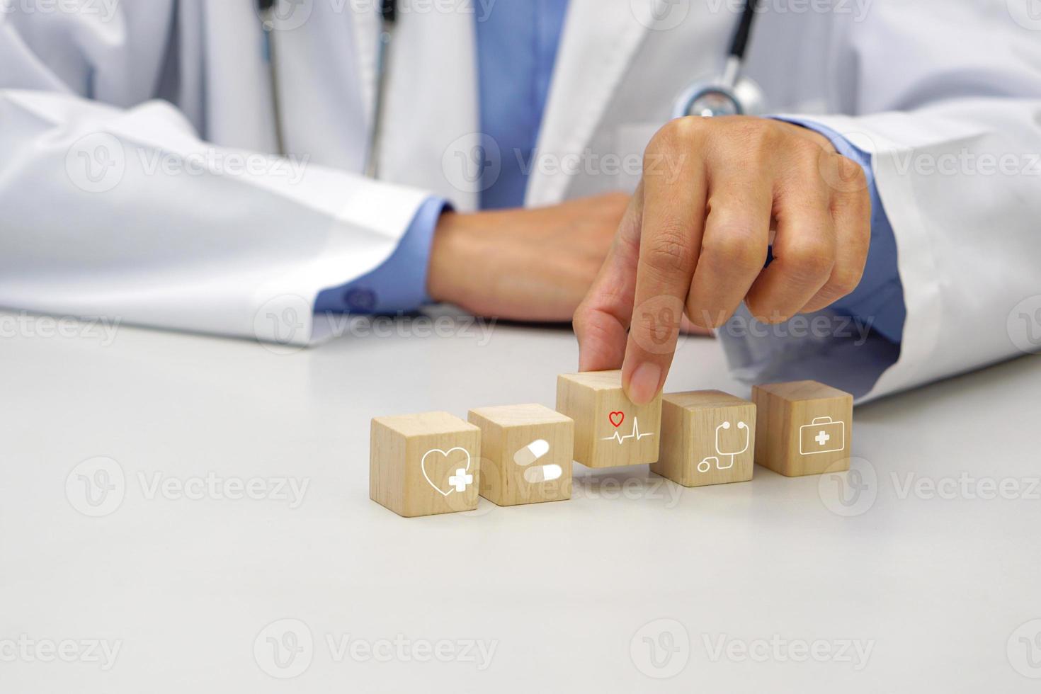 Hand holding a wooden block cube the top one with heart rate icon symbol. Medical and health concept. photo