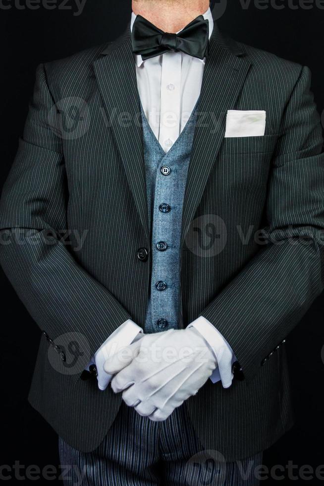 Butler in Formal Suit and White Gloves Standing at Attention. At Your Service Concept. Professional Hospitality and Care. photo