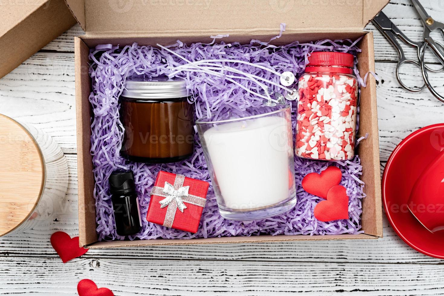 Seasonal gift box for valentine day with candle, red cup and heart shape sweets photo