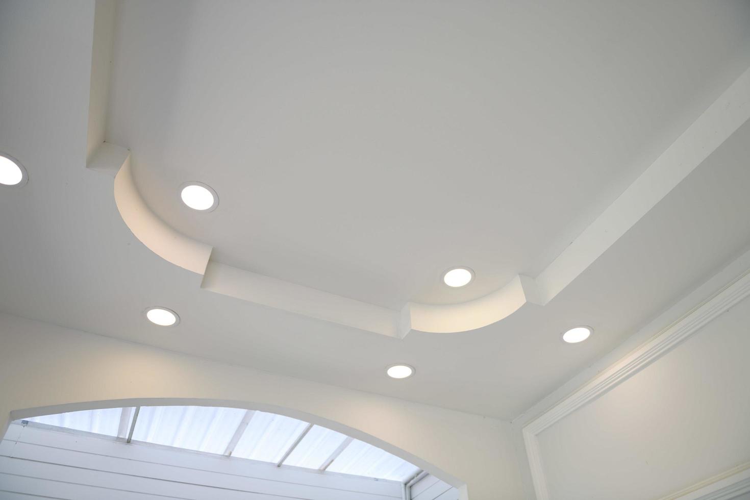 Stretch ceiling white and complex shape. ceiling with halogen spots lamps and drywall construction in empty room in exhibition hall or house. photo