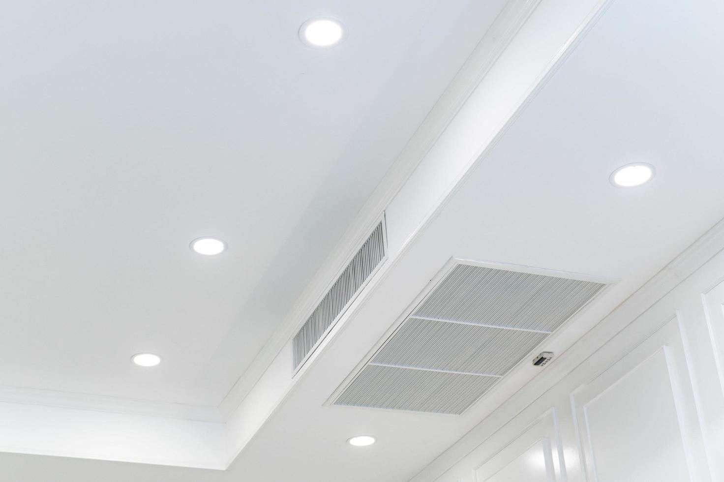 Ceiling mounted cassette type air conditioner and modern lamp light on white ceiling. duct air conditioner for home or office photo