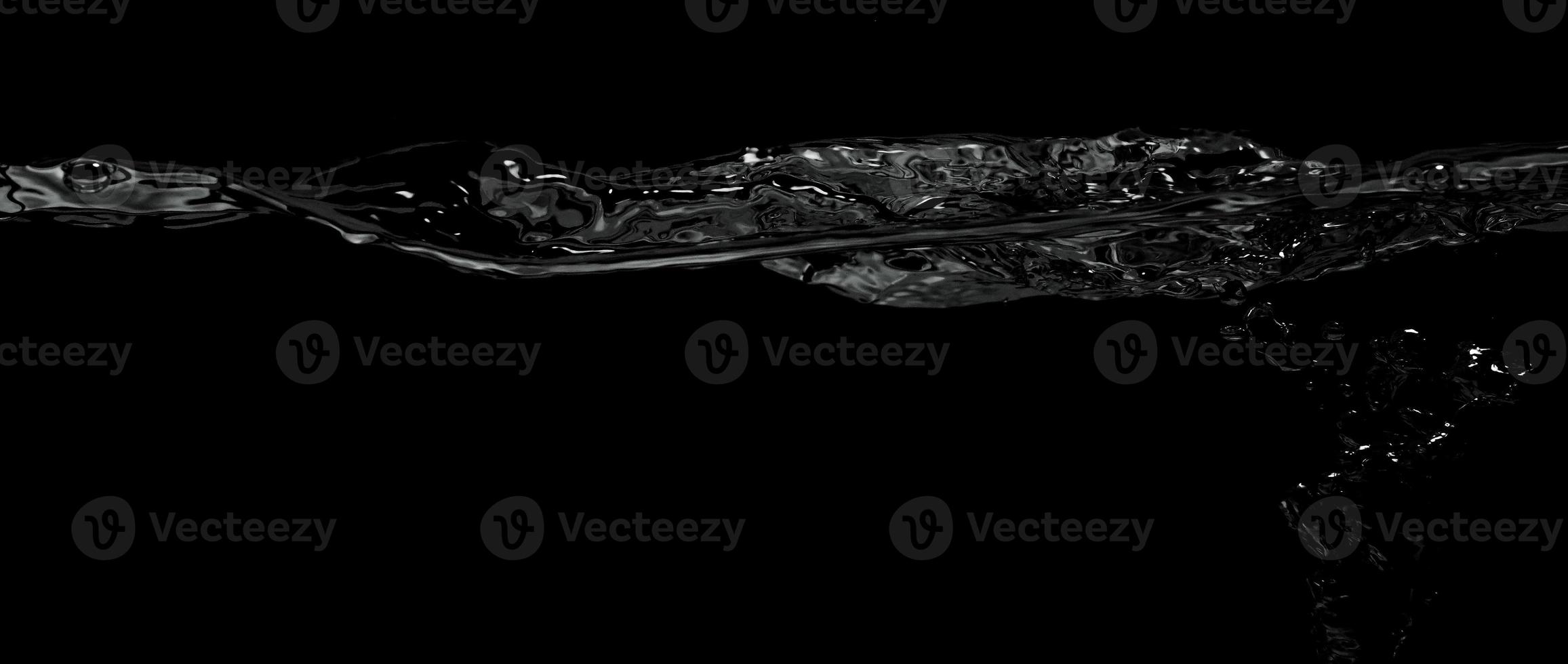Liquid suface line between underwater and above water with black background. photo