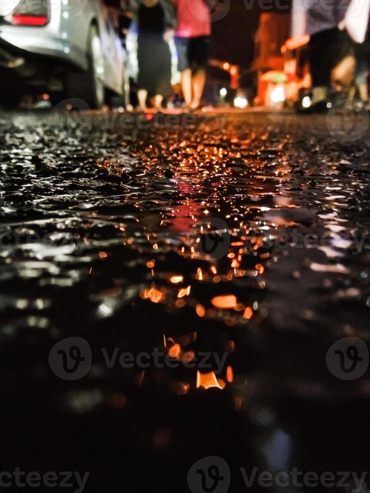 Road after rain with reflection of car headlights photo