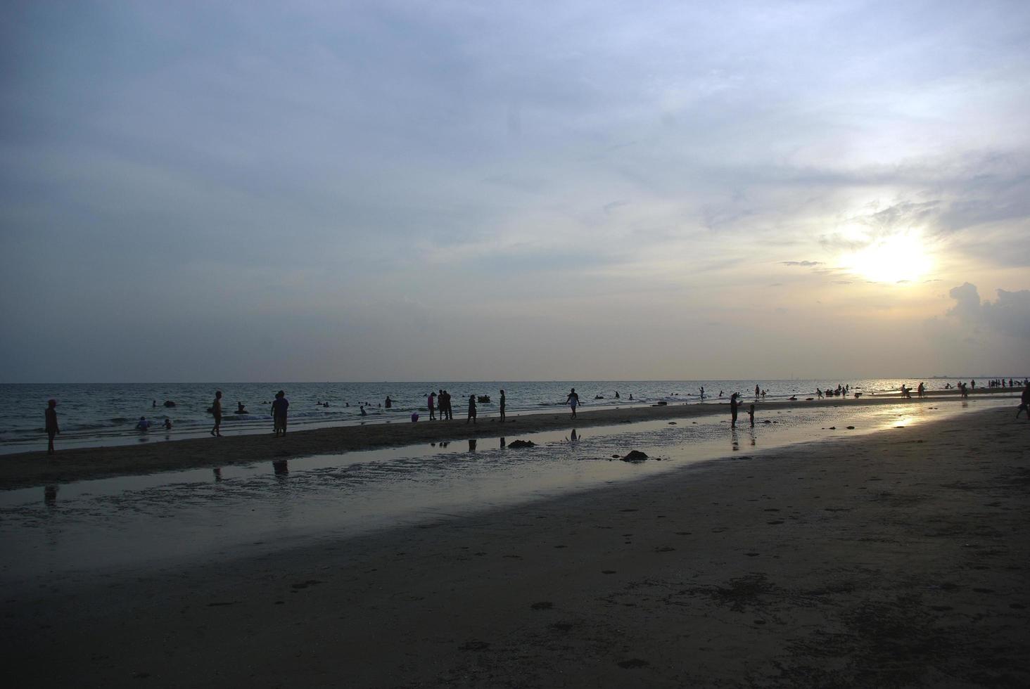 mar con sol vespertino muchos turistas llenan la playa. foto