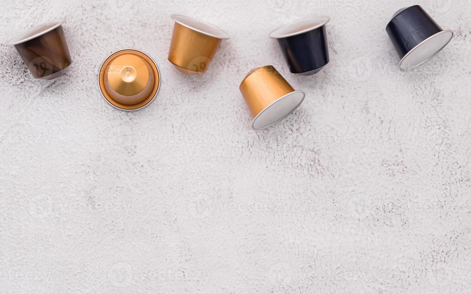 Coffee capsule setup on white concrete background with copy space. photo