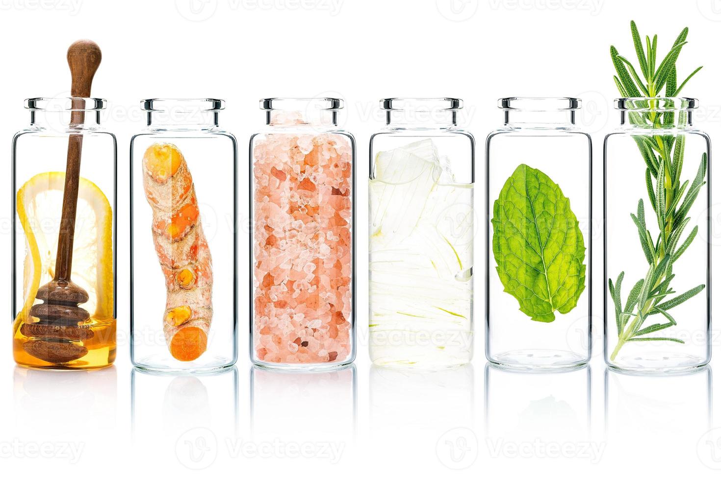 The glass bottle of homemade skin care and body scrubs with natural ingredients aloe vera ,himalayan salt ,peppermint ,rosemary ,turmeric and honey isolate on white background. photo