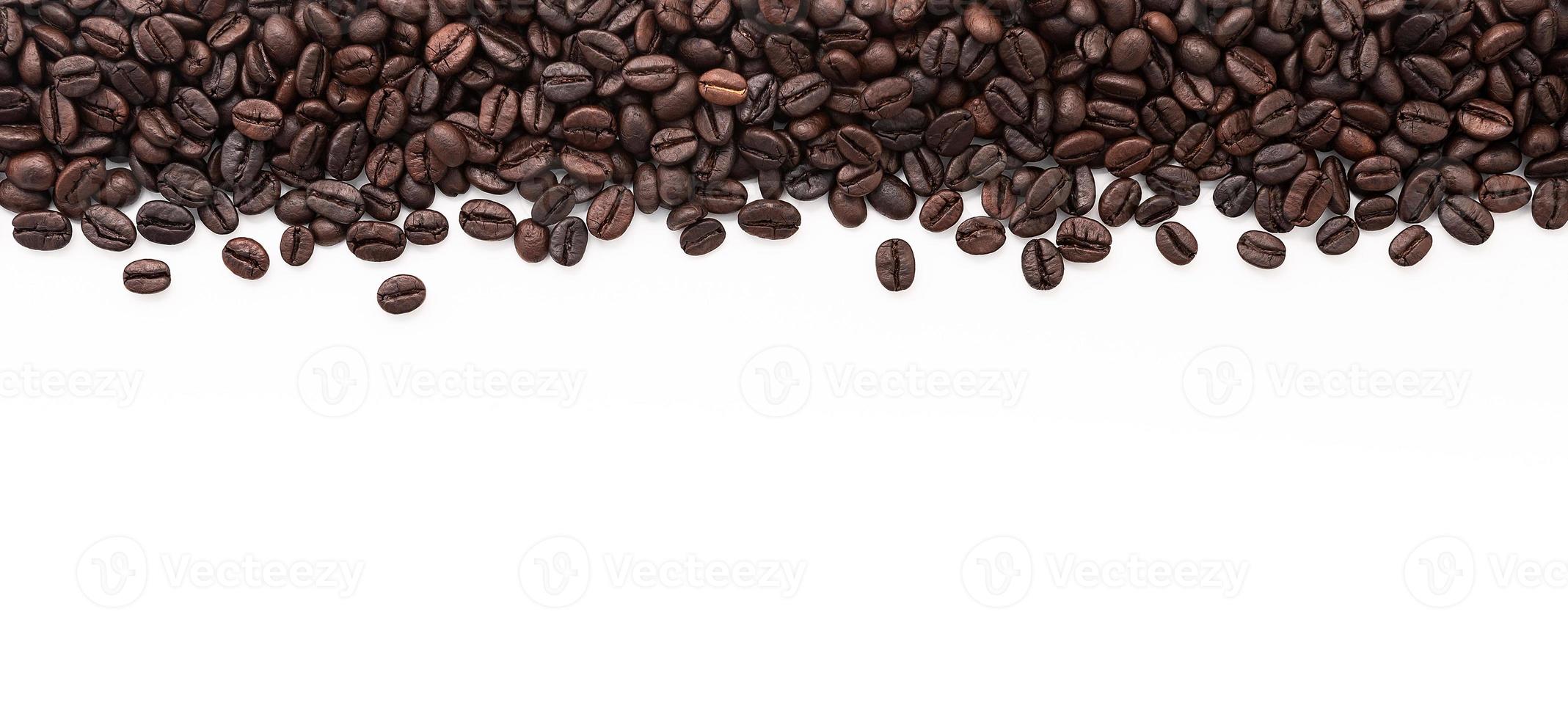 Dark roasted coffee beans setup on white background with copy space. photo