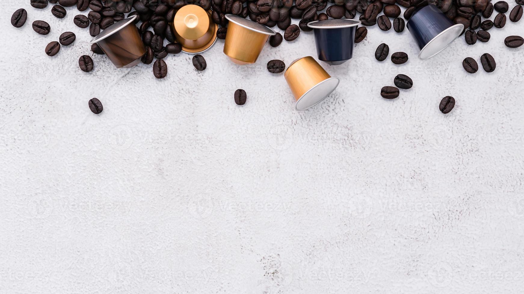 Dark roasted coffee beans setup on white concrete background with copy space. photo