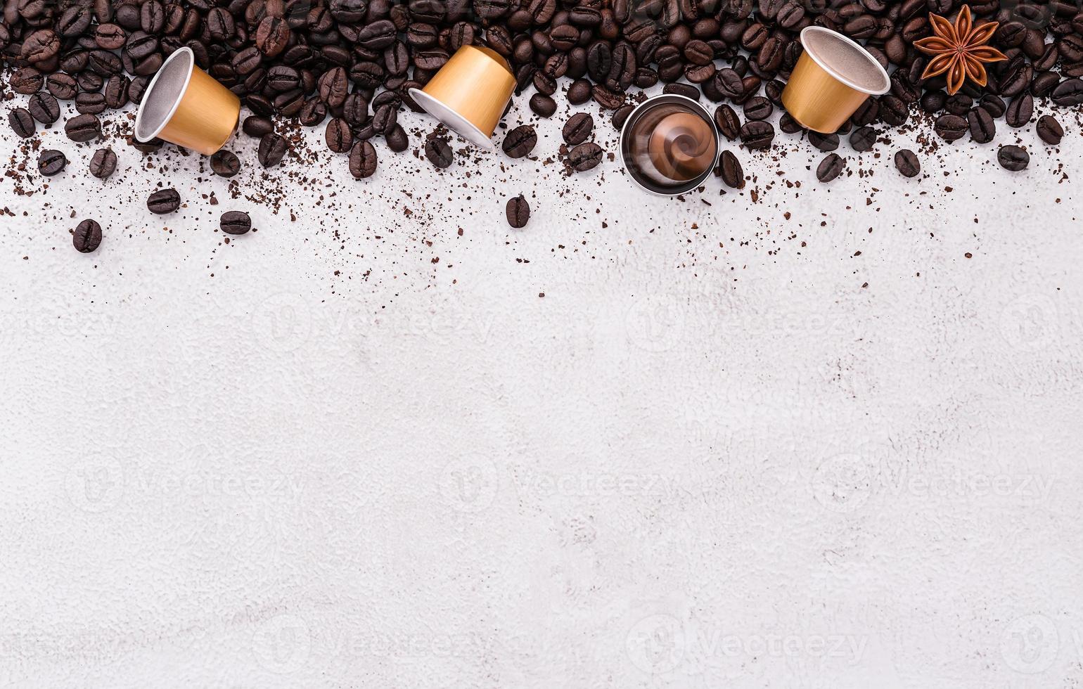 Dark roasted coffee beans setup on white concrete background with copy space. photo