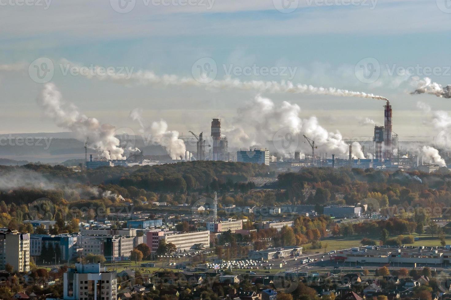 panoramic aerial view of the smoke of pipes as background of huge residential complex with high-rise buildings and private sector . Air and water pollution concept photo