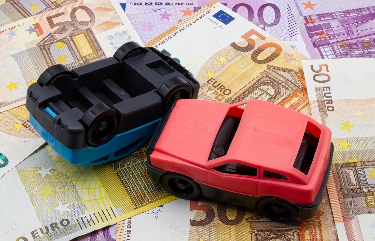 Accident of two cars isolated on a background of euro banknotes. Car crash concept. photo