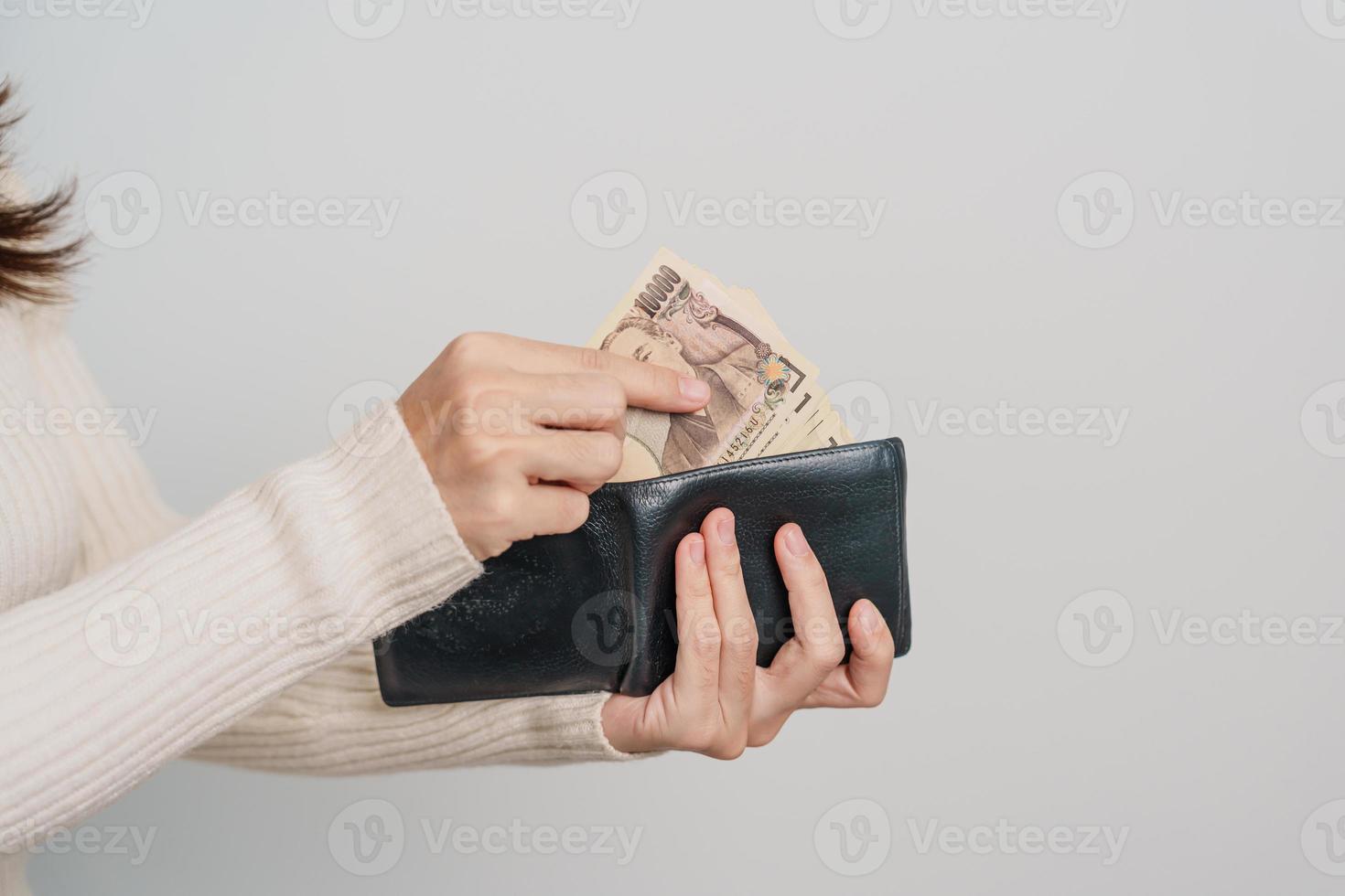 Woman hand holding Japanese Yen banknote with wallet. Thousand Yen money. Japan cash, Tax, Recession Economy, Inflation, Investment, finance and shopping payment concepts photo
