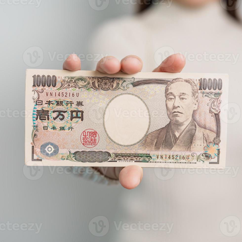 Woman hand holding Japanese Yen banknote stack. Thousand Yen money. Japan cash, Tax, Recession Economy, Inflation, Investment, finance and shopping payment concepts photo