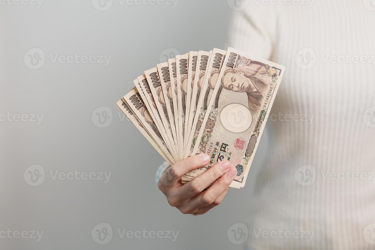 Woman hand holding Japanese Yen banknote stack. Thousand Yen money. Japan cash, Tax, Recession Economy, Inflation, Investment, finance and shopping payment concepts photo