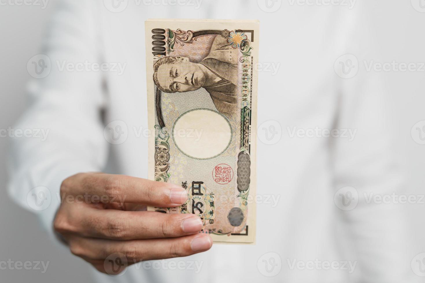 man hand holding Japanese Yen banknote stack. Thousand Yen money. Japan cash, Tax, Recession Economy, Inflation, Investment, finance and shopping payment concepts photo