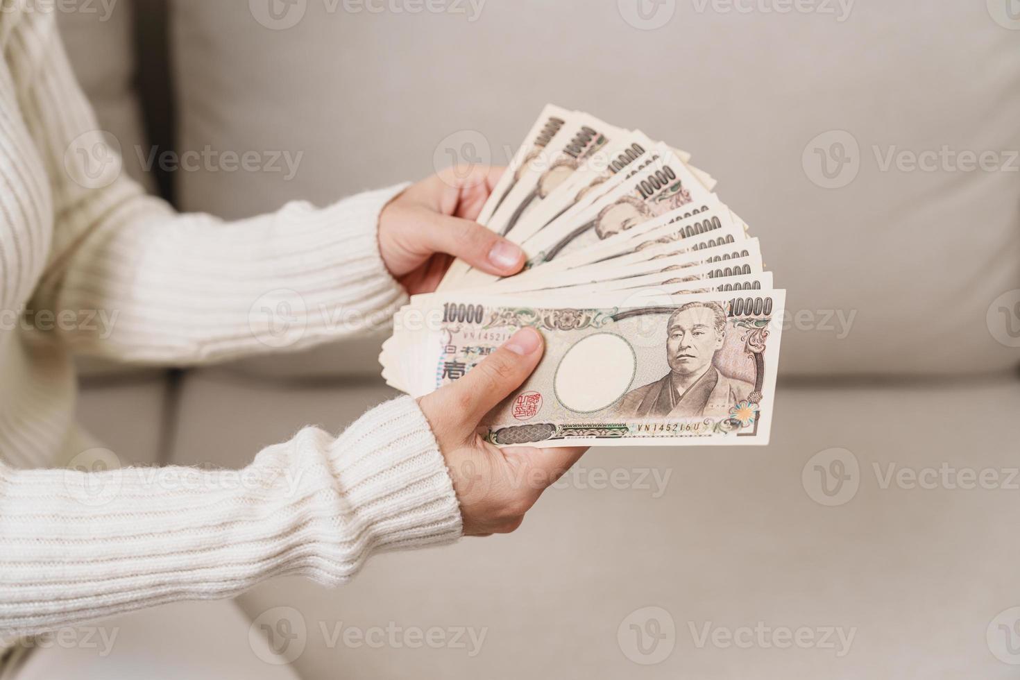 Woman hand holding Japanese Yen banknote stack. Thousand Yen money. Japan cash, Tax, Recession Economy, Inflation, Investment, finance and shopping payment concepts photo