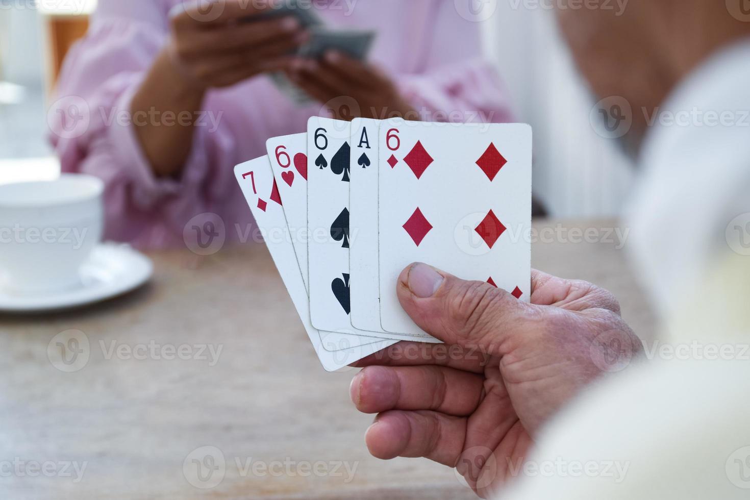 Card playing of elderly people at home in their freetimes, recreation and happiness of elderly people concept. photo