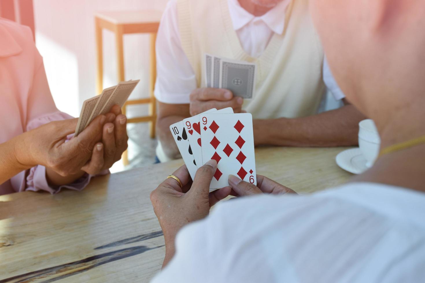 Card playing of elderly people at home in their freetimes, recreation and happiness of elderly people concept. photo