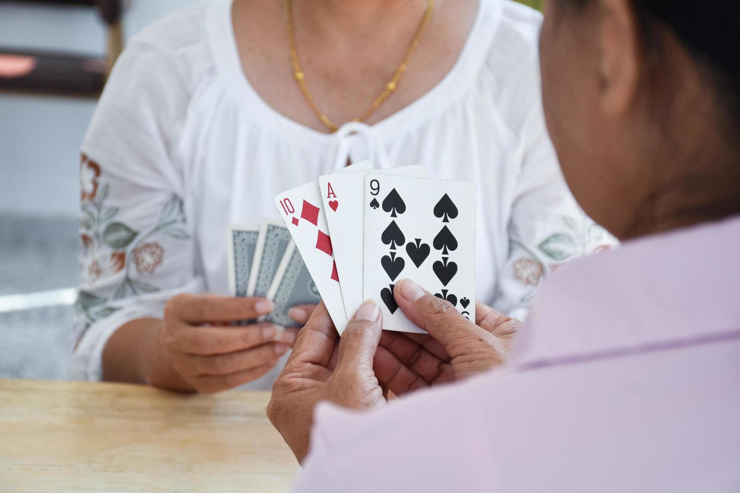 juego de cartas de personas mayores en casa en su tiempo libre, recreación y felicidad del concepto de personas mayores. foto