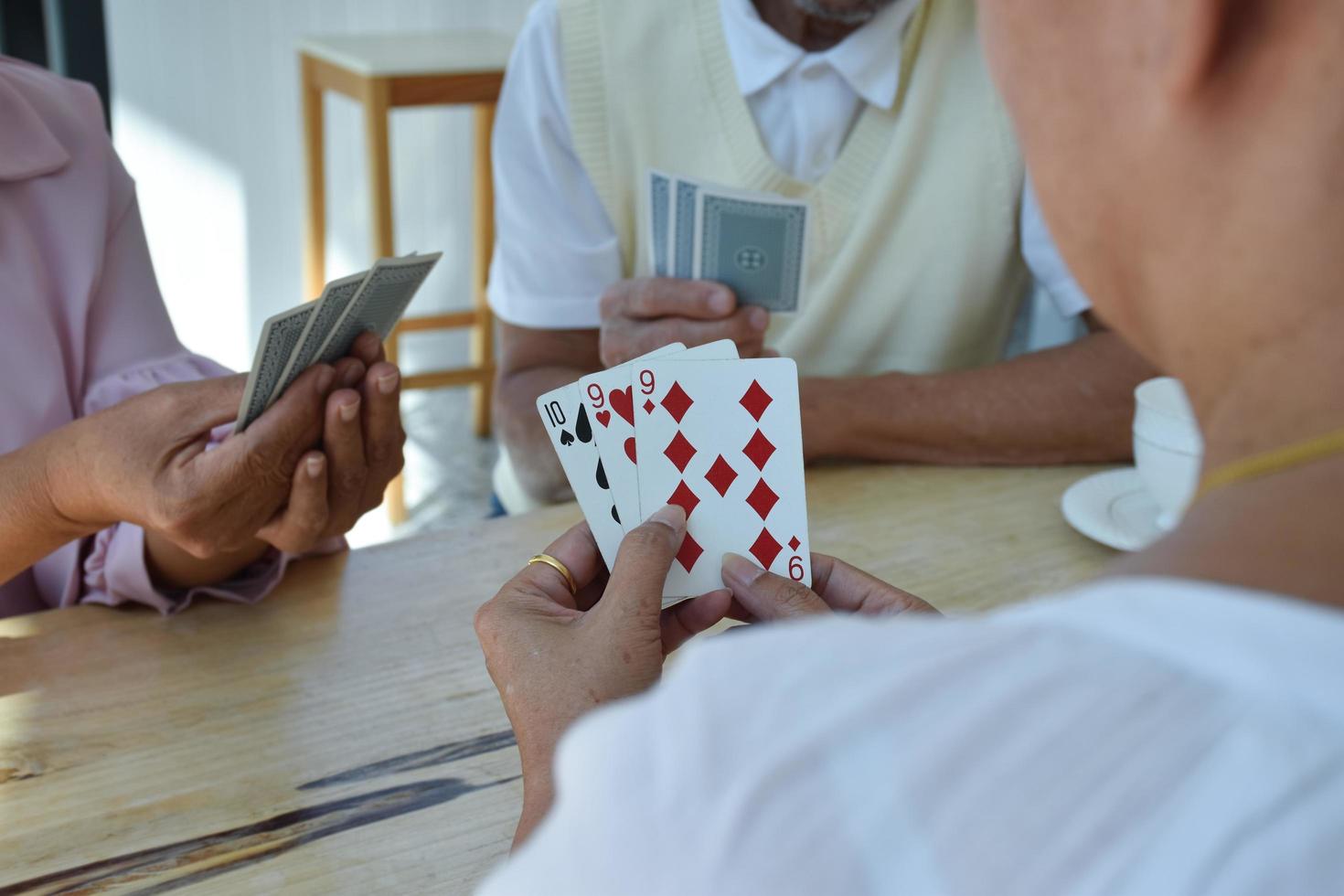 Card playing of elderly people at home in their freetimes, recreation and happiness of elderly people concept. photo