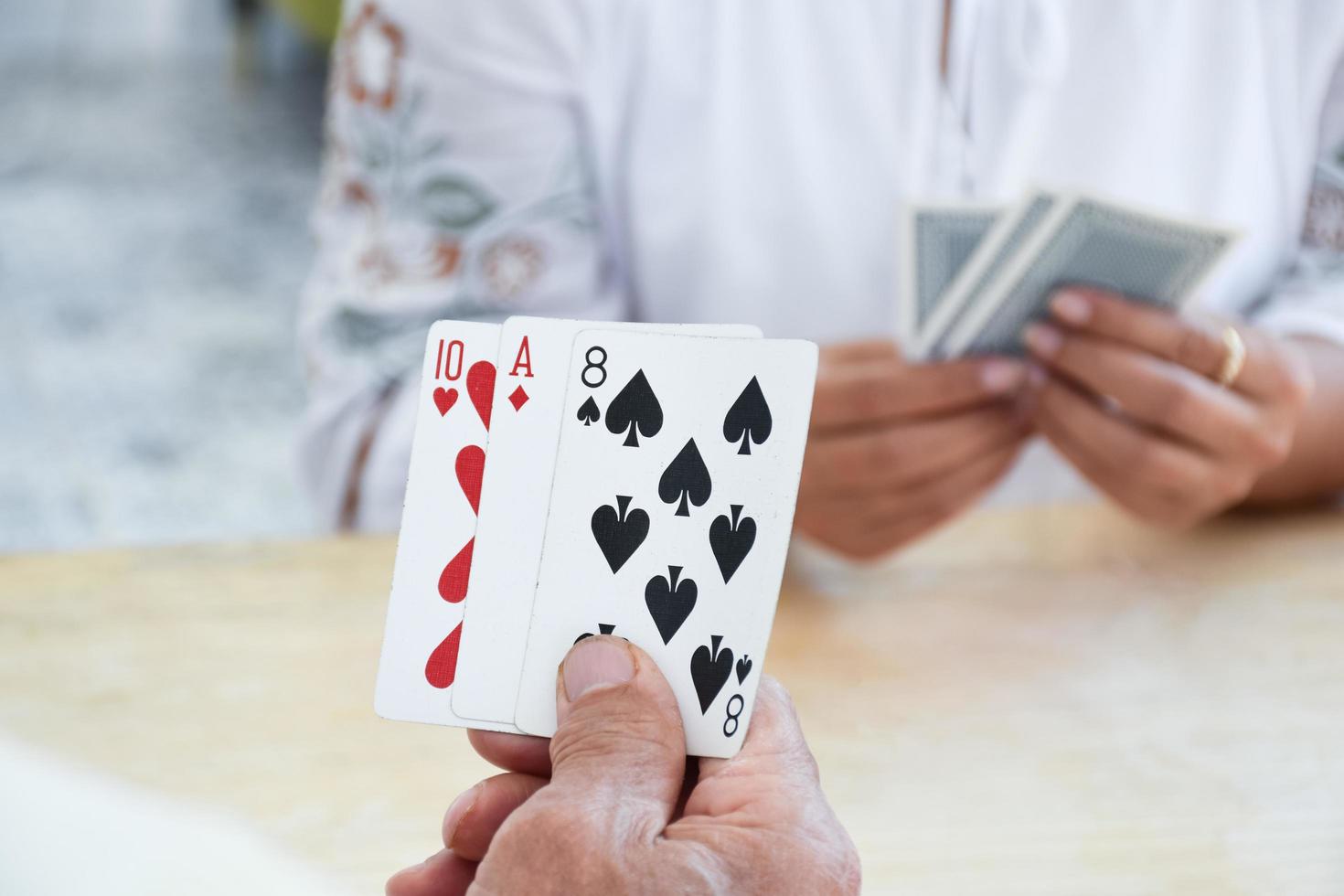 Card playing of elderly people at home in their freetimes, recreation and happiness of elderly people concept. photo