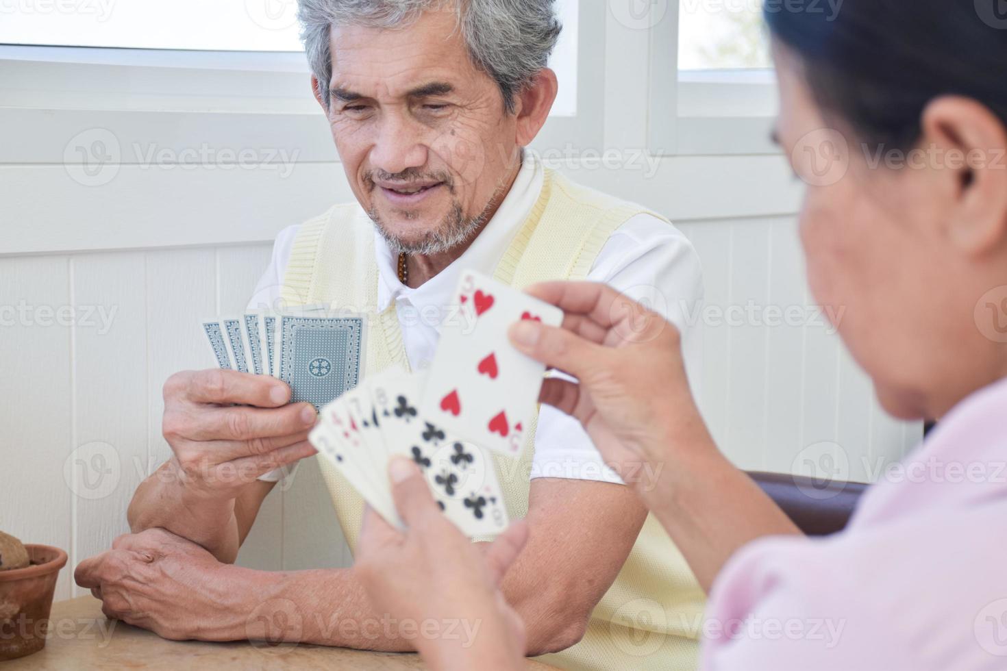 juego de cartas de personas mayores en casa en su tiempo libre, recreación y felicidad del concepto de personas mayores. foto