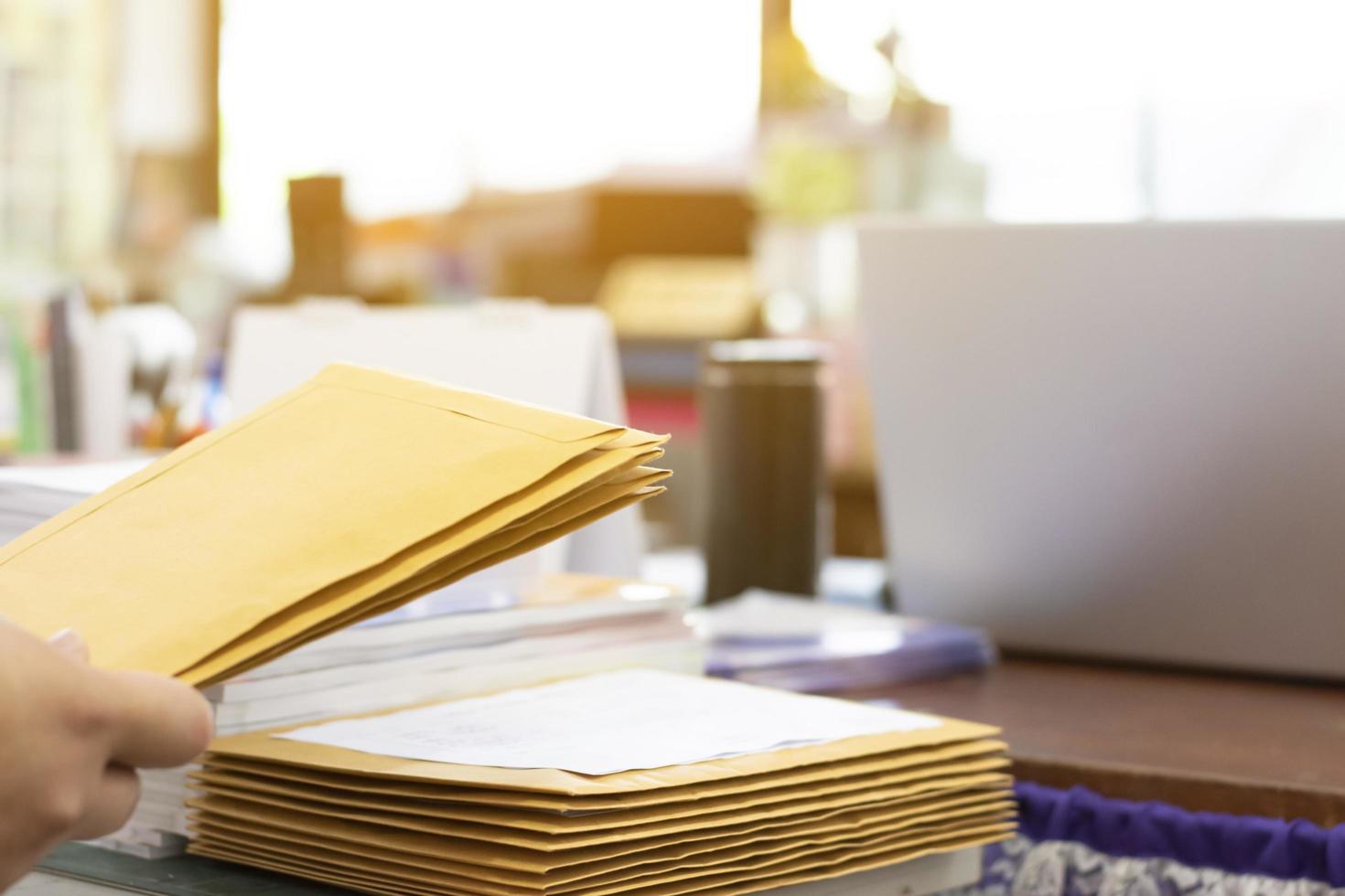 Soft focus of office clerk or secretary is preparing documents and brown envelopes for those interested in bidding for the construction of a large building in an office. photo