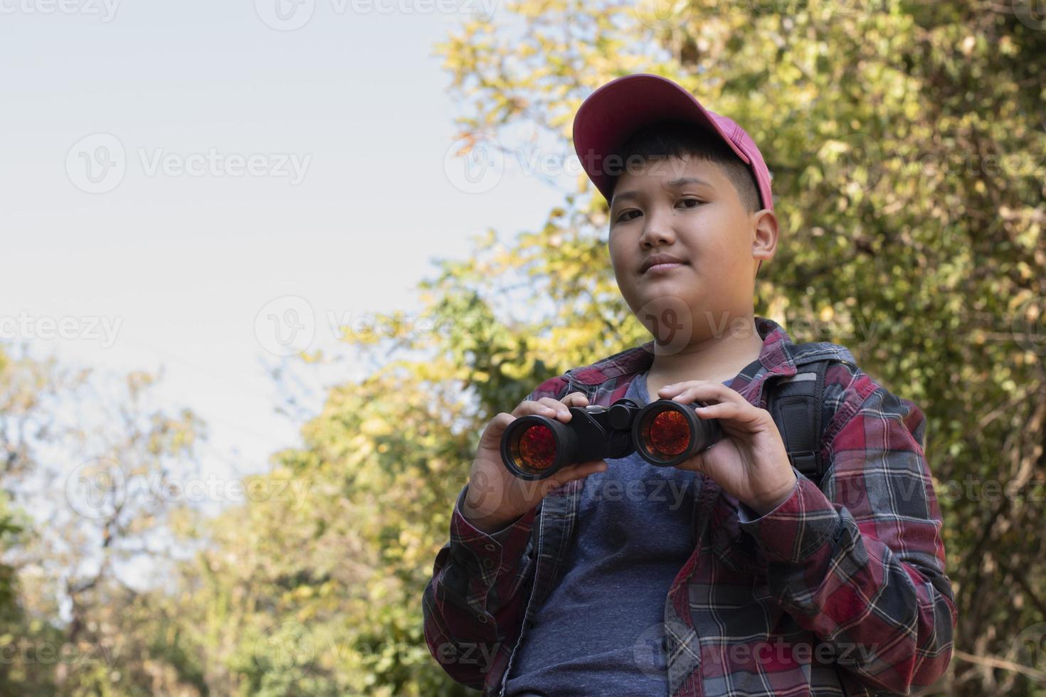 los niños asiáticos están usando binoculares para observar aves en el bosque tropical durante el campamento de verano, idea para aprender criaturas y animales salvajes e insectos fuera del aula. foto