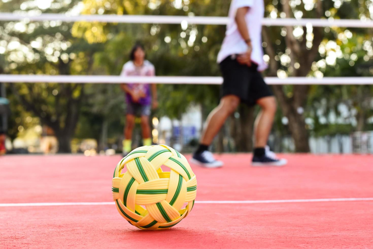 pelota sepak takraw en el piso rojo de la cancha al aire libre, fondo borroso, actividad recreativa y deportes al aire libre en el concepto de países del sudeste asiático. foto