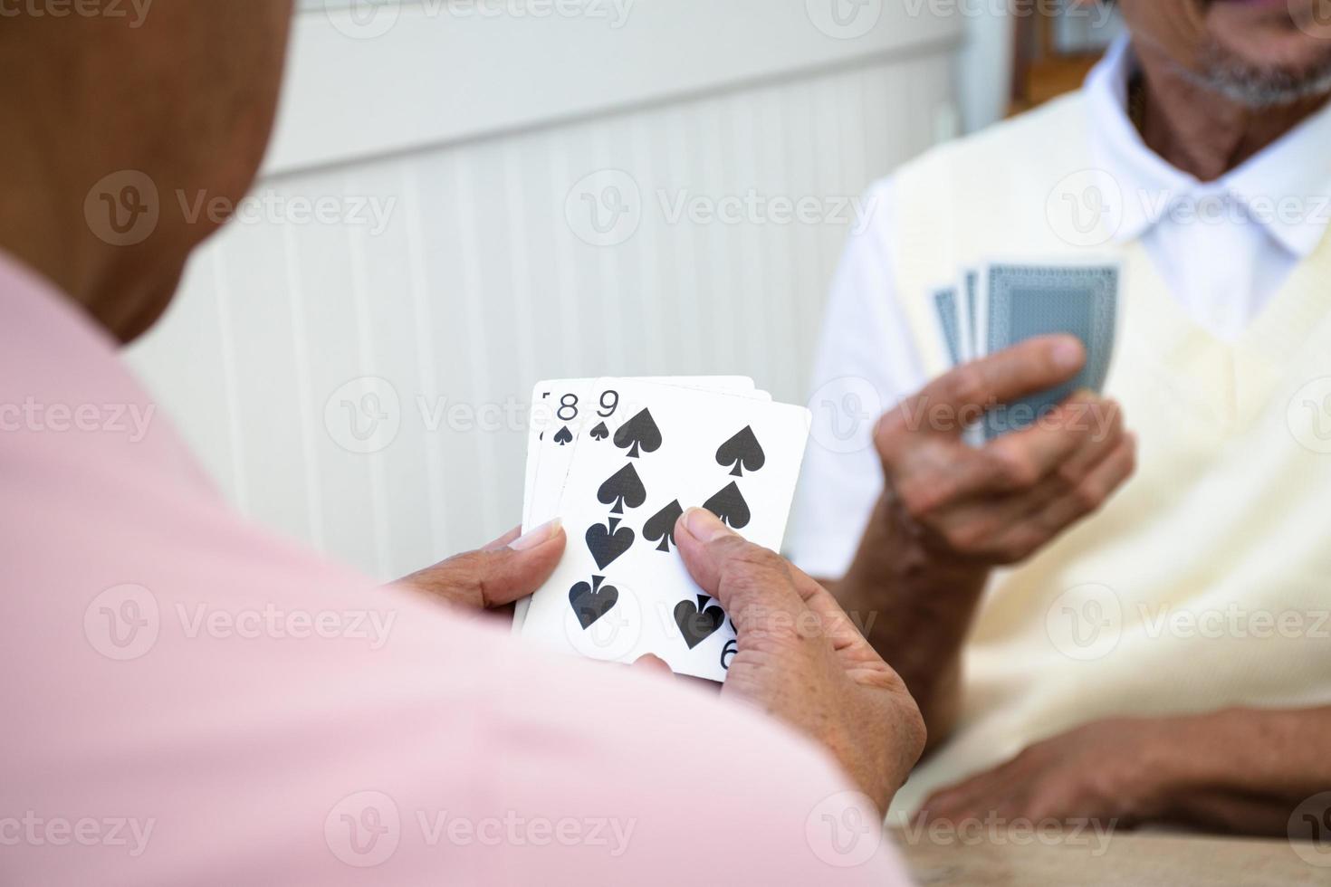 Card playing of elderly people at home in their freetimes, recreation and happiness of elderly people concept. photo