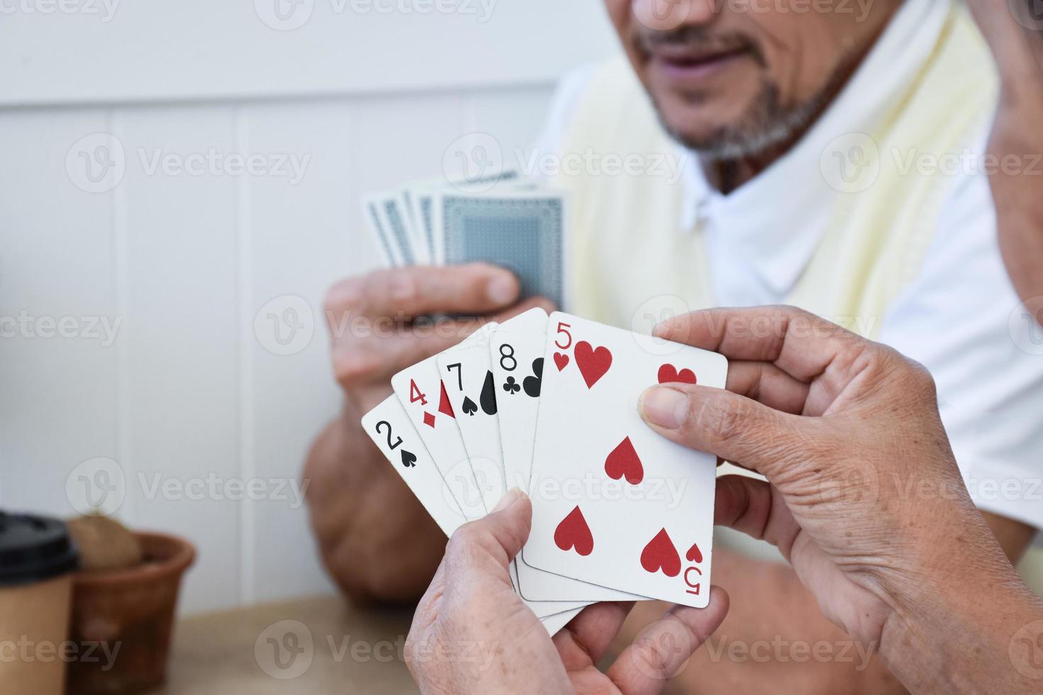 Card playing of elderly people at home in their freetimes, recreation and happiness of elderly people concept. photo