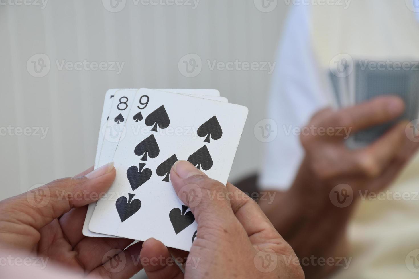Card playing of elderly people at home in their freetimes, recreation and happiness of elderly people concept. photo