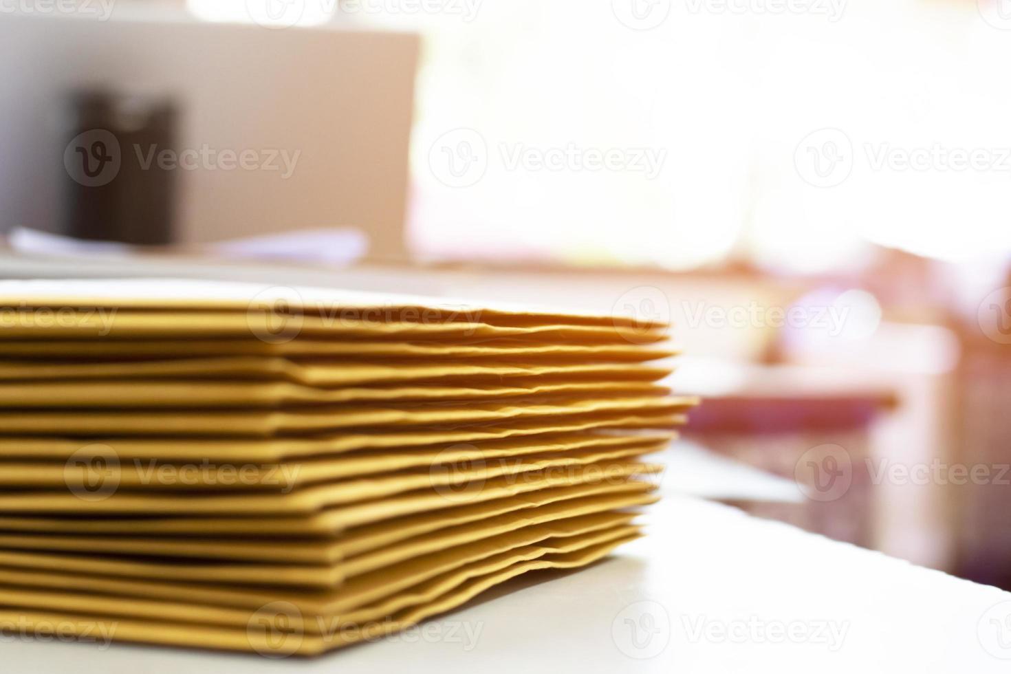 el enfoque suave del empleado de oficina o secretaria está preparando documentos y sobres marrones para aquellos interesados en licitar para la construcción de un gran edificio en una oficina. foto