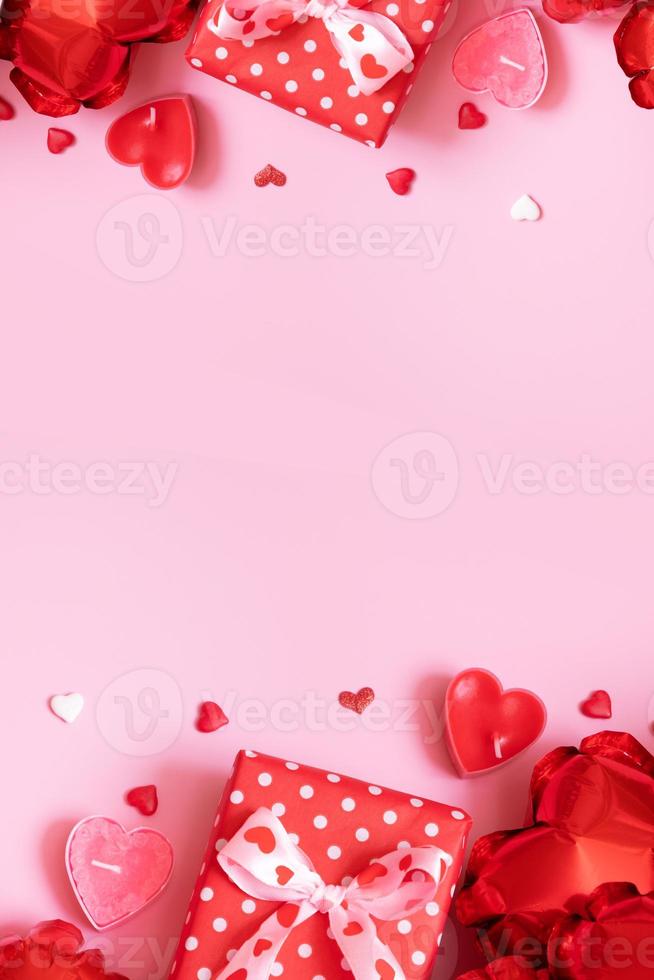 Gift box, candels and red heart shape baloons on pink background. Valentines Day concept photo