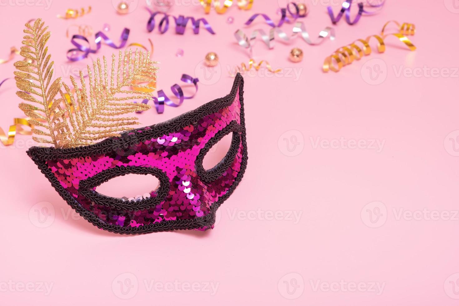 Festive face mask for masquerade or carnival celebration on colored background. Copy space photo