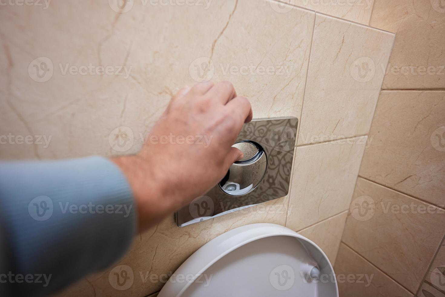 Hand of man push toilet flush press with two separate buttons. photo